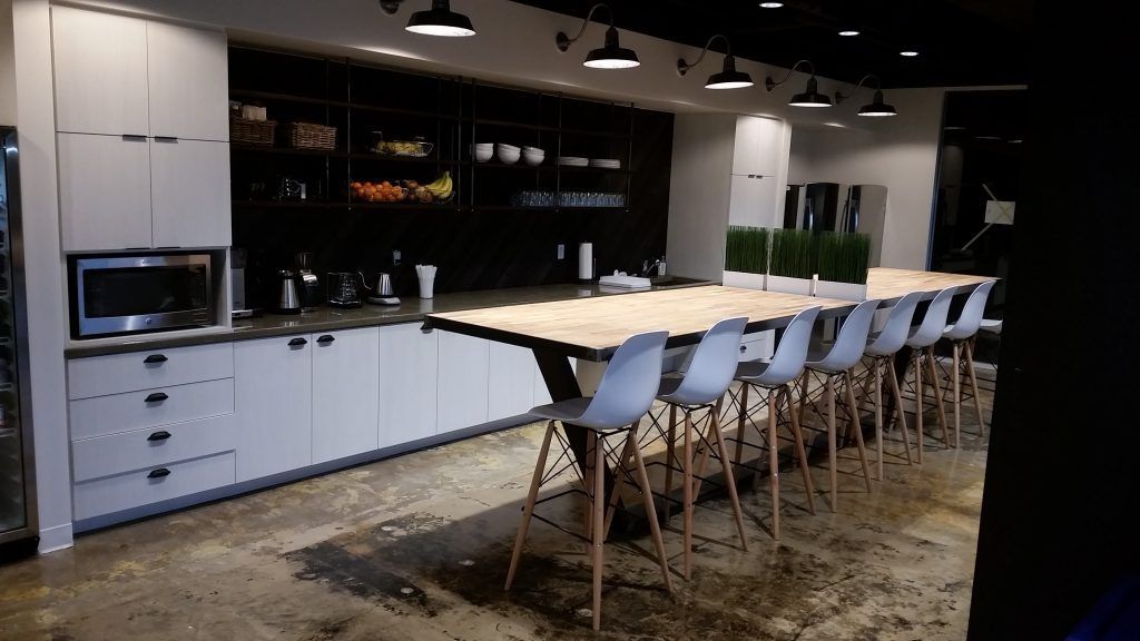 A kitchen with a long table and chairs in it