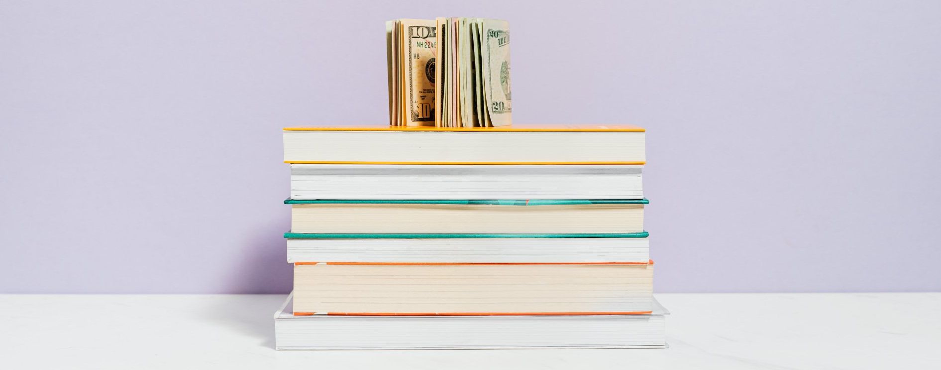 a stack of books with money on top