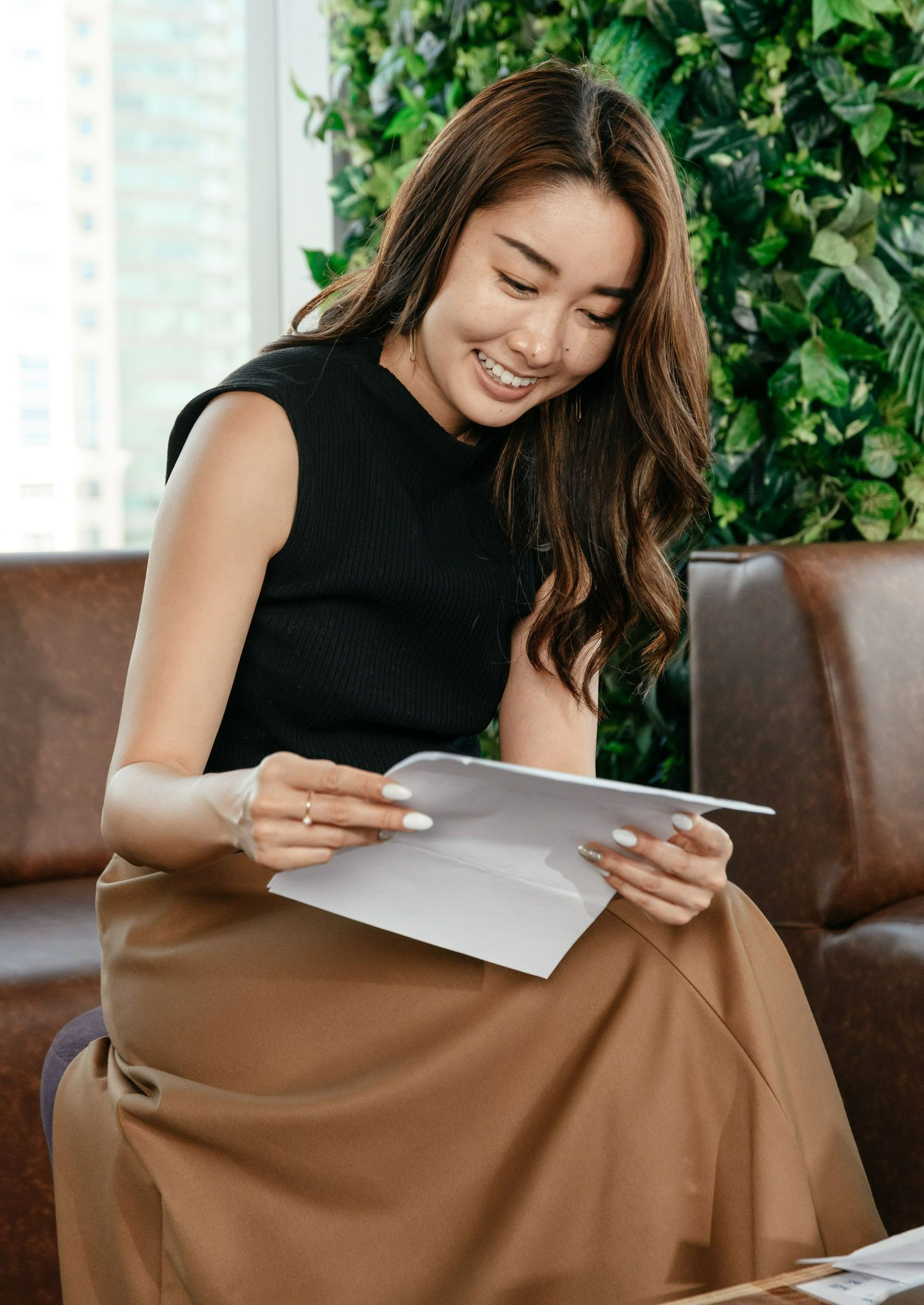 : a person sitting on a couch reading a paper