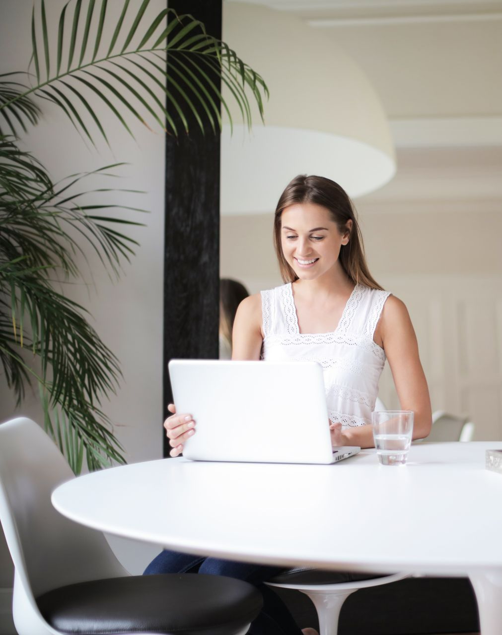a girl sitting at a table with a laptop