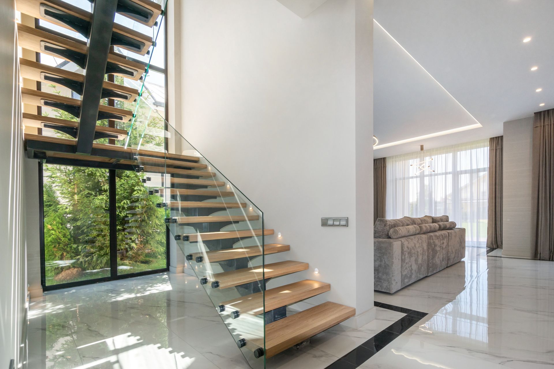 An elegant wooden staircase with glass railings.