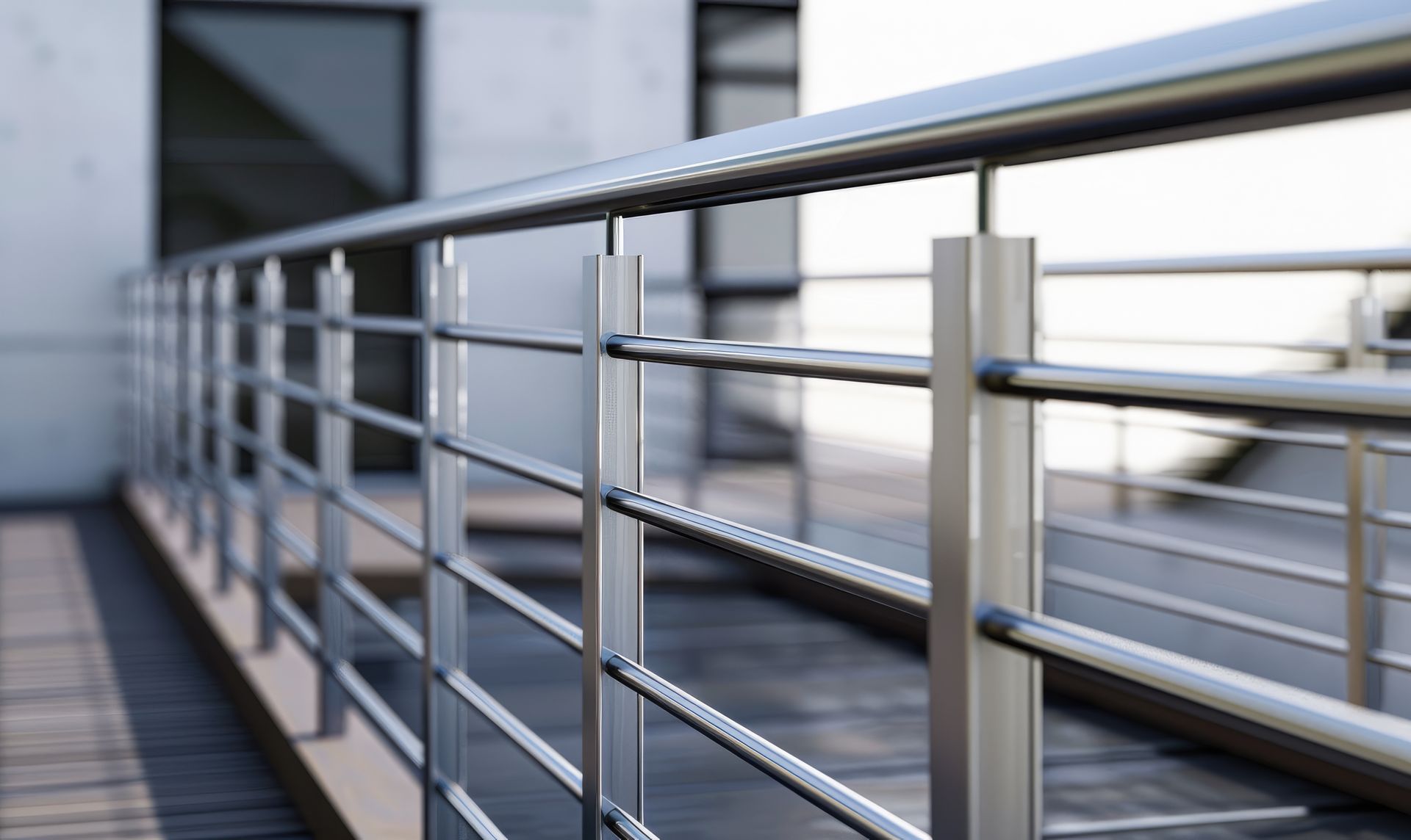 Metal railing on a modern balcony or walkway with a blurred building in the background