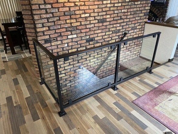 interior stair railing with black metal frame and clear glass panels