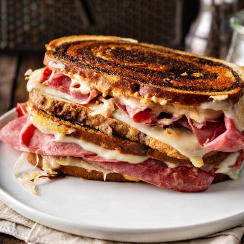 A grilled cheese sandwich is stacked on top of each other on a white plate.