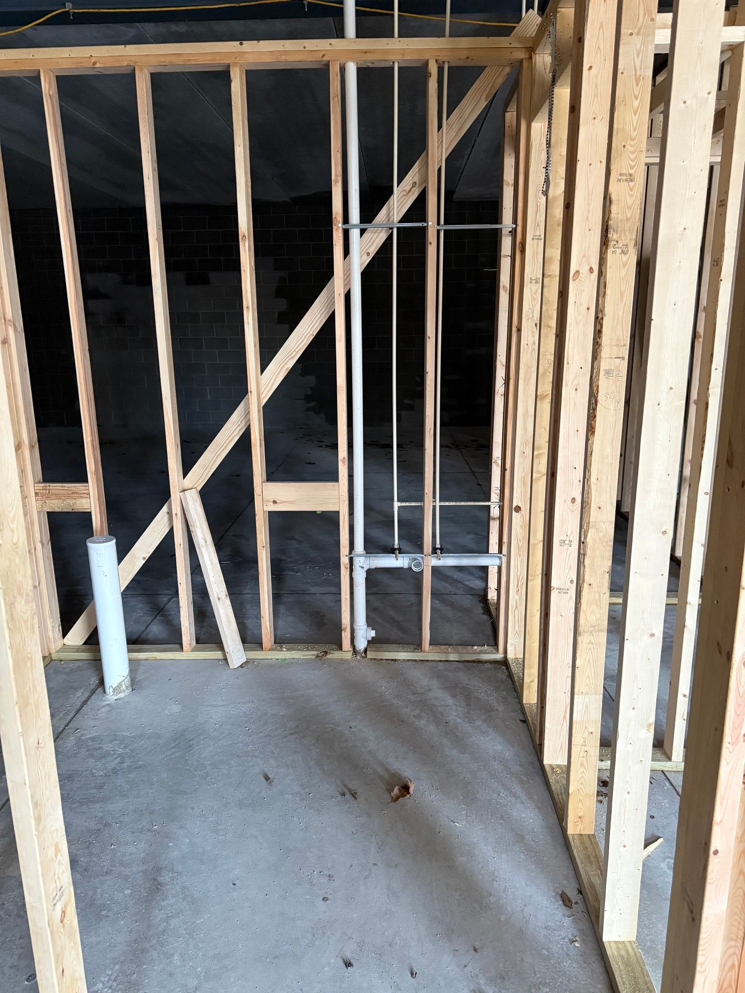 Framed interior of a building under construction with exposed studs and a concrete floor