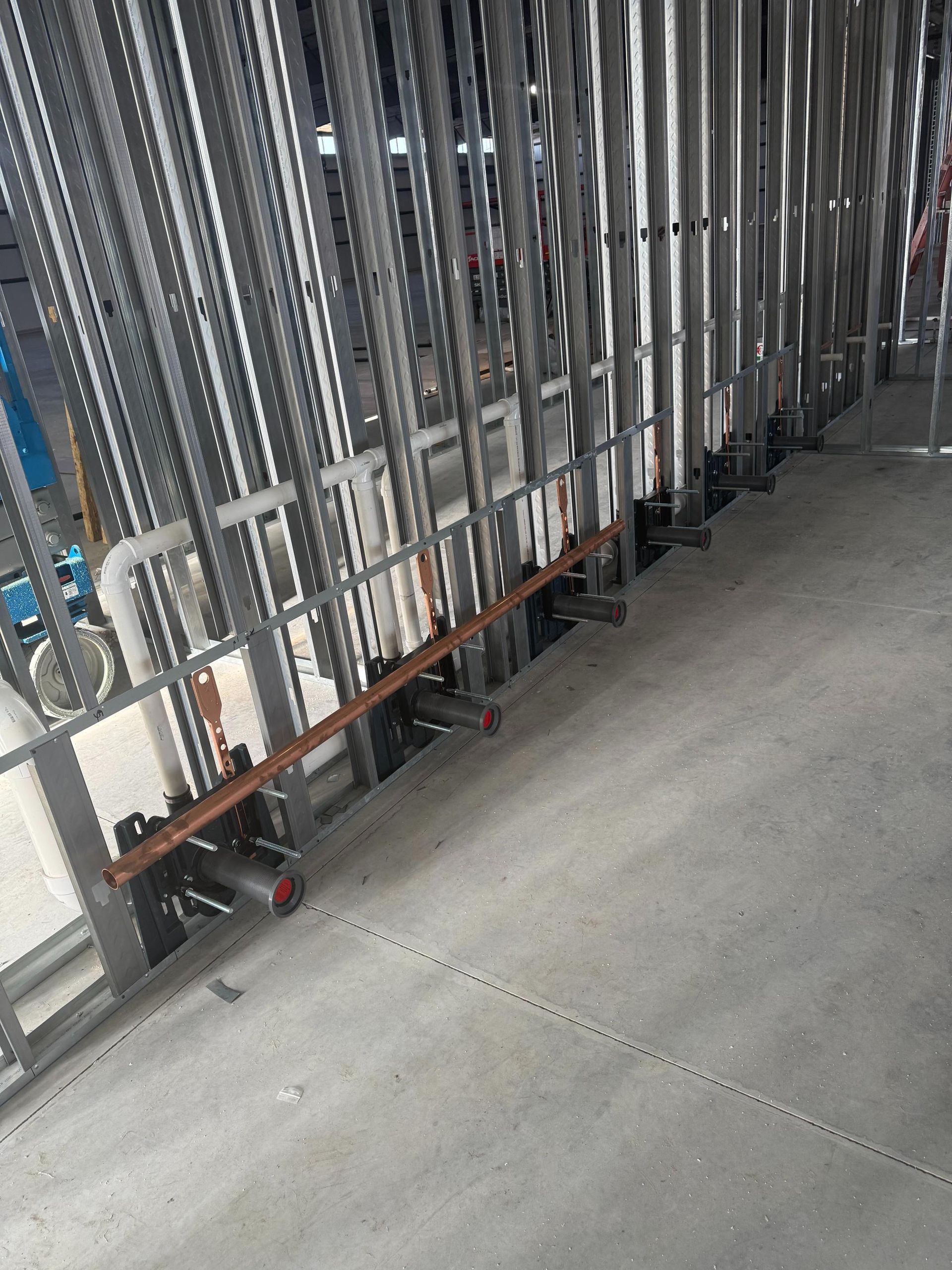 Metal barriers with wheels lined up on a concrete floor in an industrial or storage area