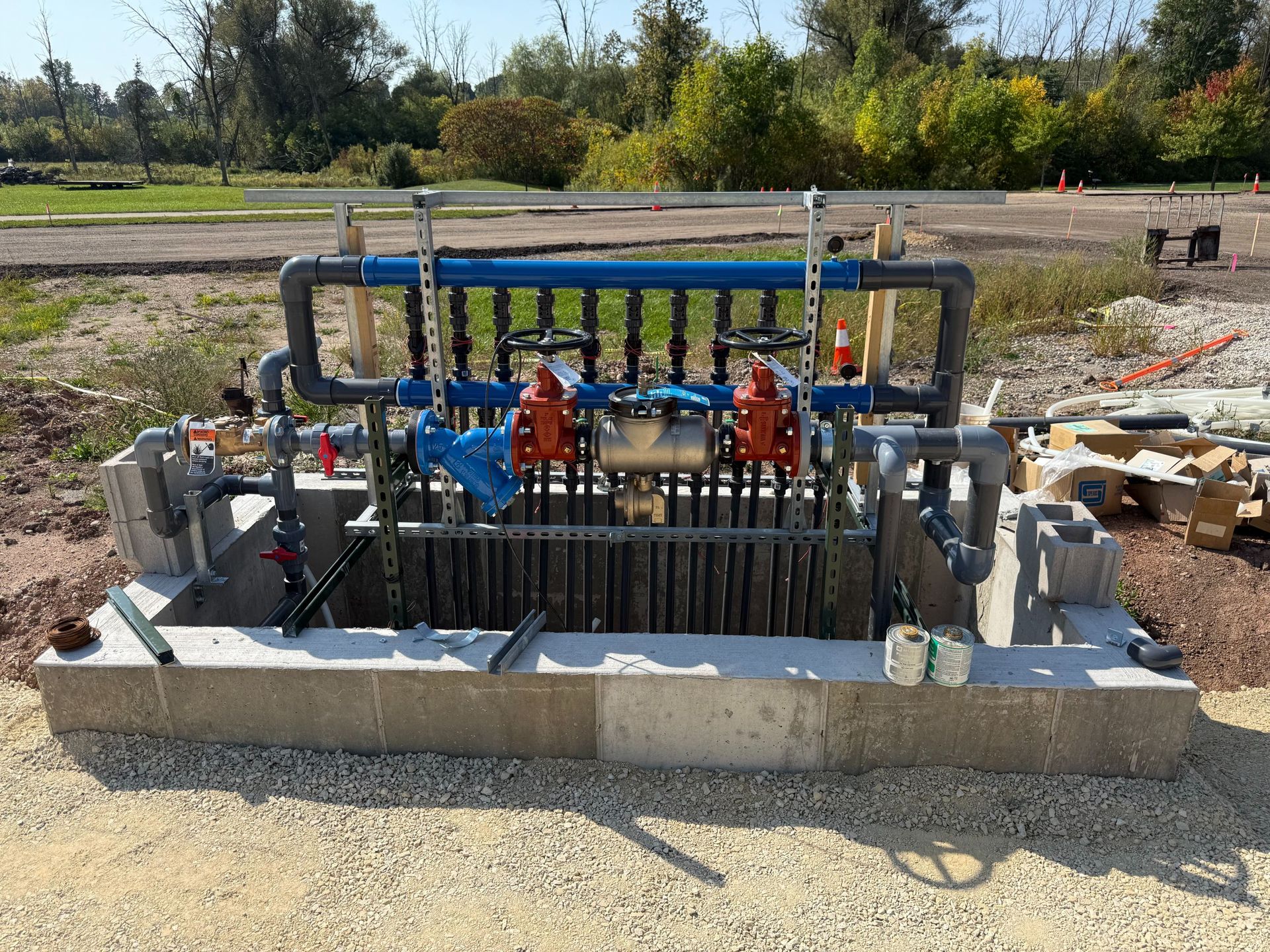 Industrial pump and piping system mounted in a concrete basin at an outdoor construction site