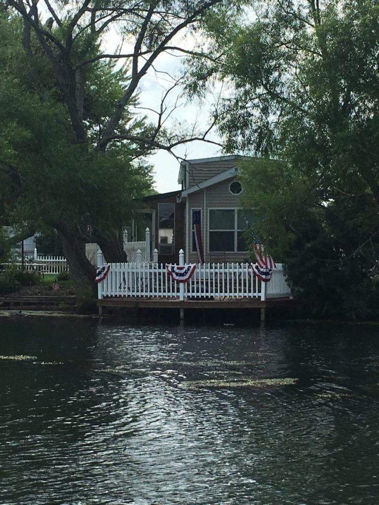 A small house sits on a dock overlooking a body of water