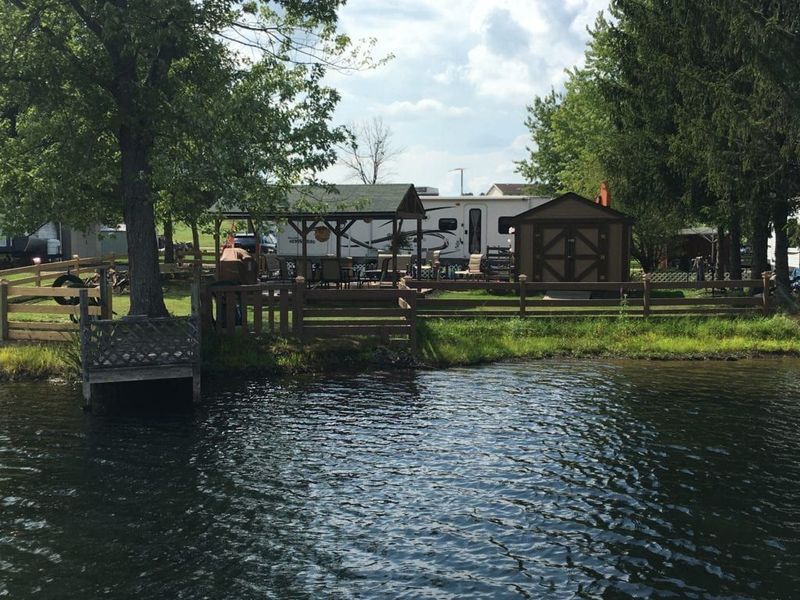 A shed sits on a small island in the middle of a lake