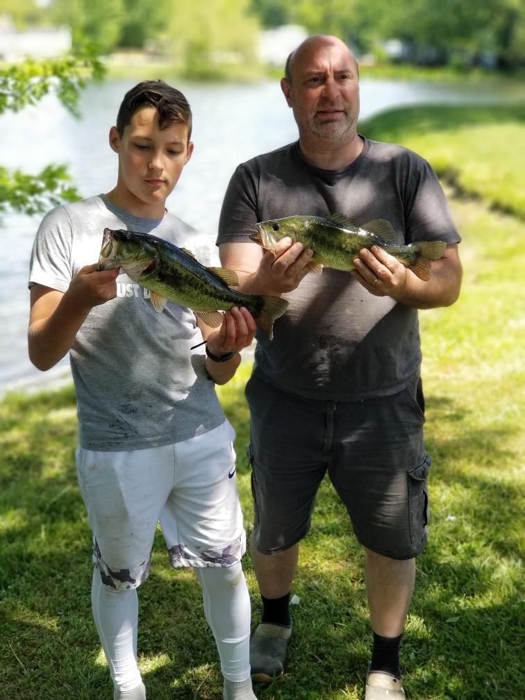 A man and a boy are holding a large fish in their hands