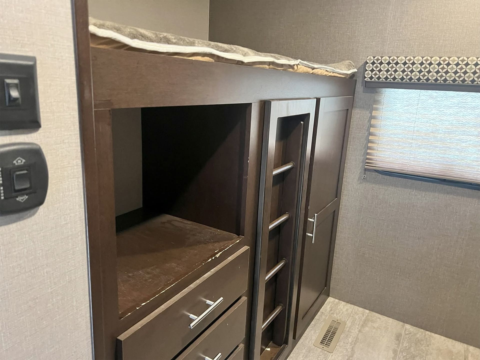 Broken upper cabinet with exposed wood interior in an RV or camper kitchen area