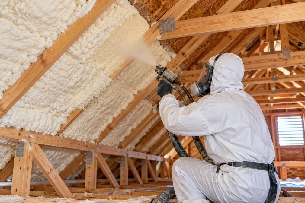 Spray foam insulation being applied to attic roof rafters in Odessa, Texas.
