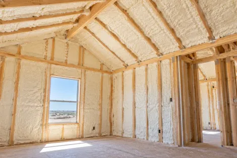 Completed closed-cell spray foam insulation covering attic walls and roof rafters in Odessa, Texas.