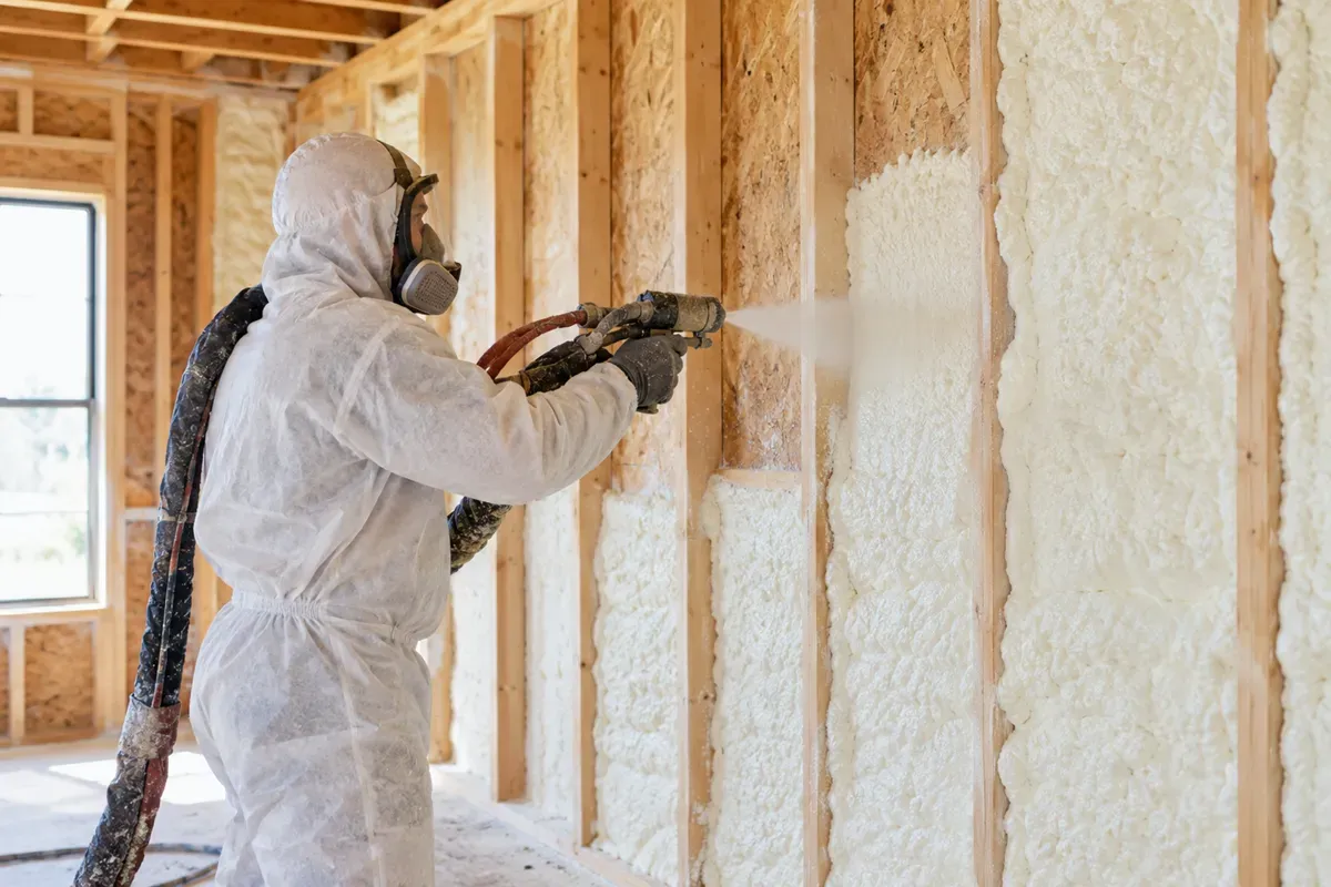Worker applying closed-cell spray foam insulation in Odessa, TX