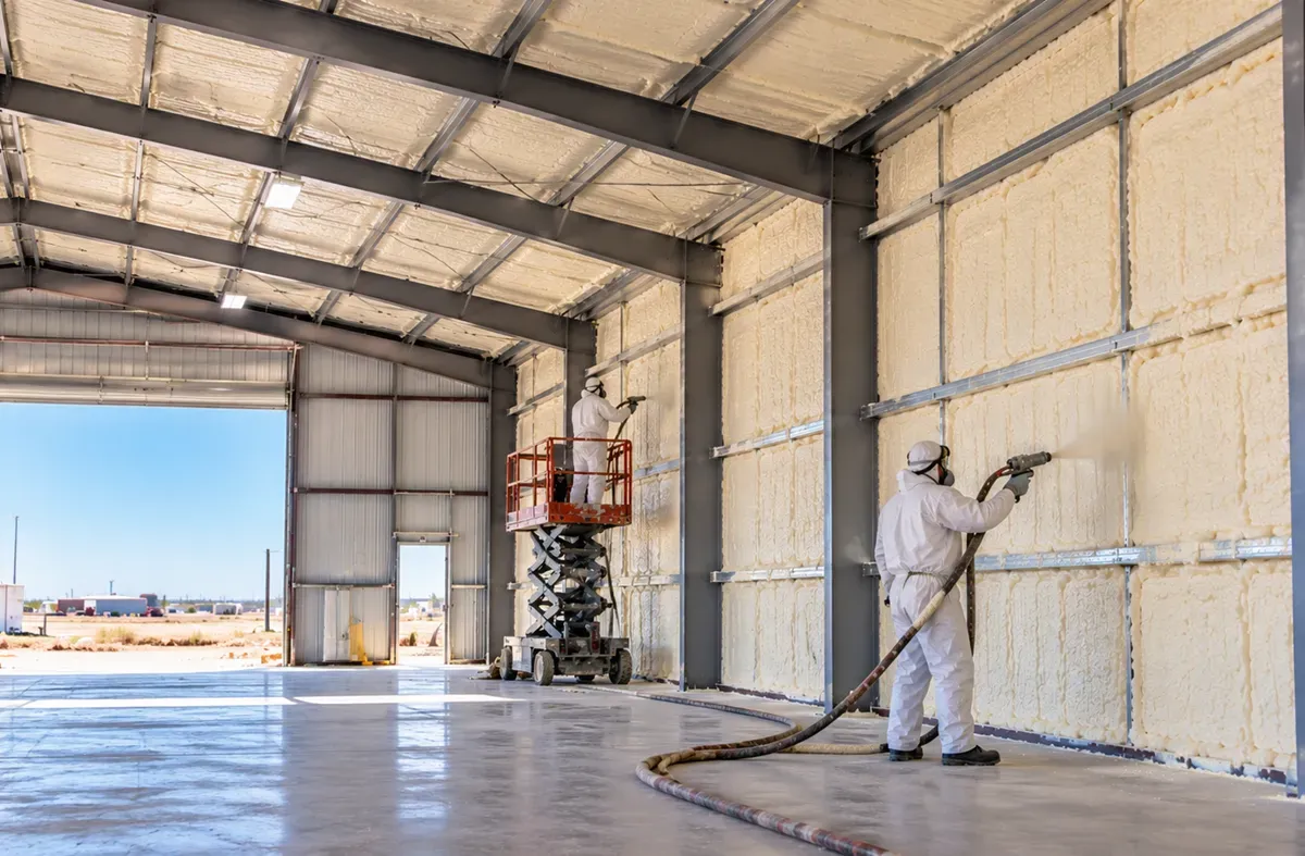 Spray foam insulation in a metal warehouse with an open entry door in Odessa, TX.
