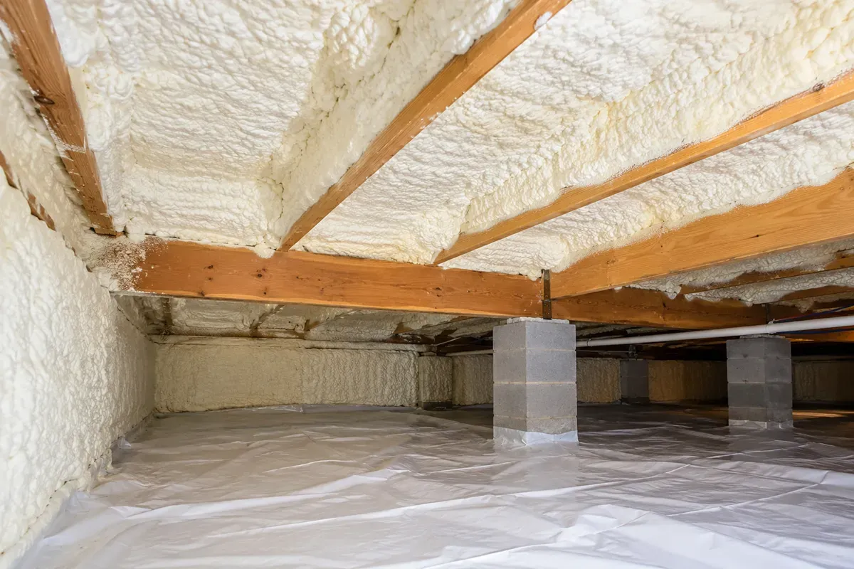 Completed crawl space with spray foam insulation between floor joists in Odessa, TX