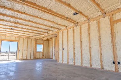Completed open-cell spray foam insulation on ground-floor walls and ceiling in Odessa, Texas.