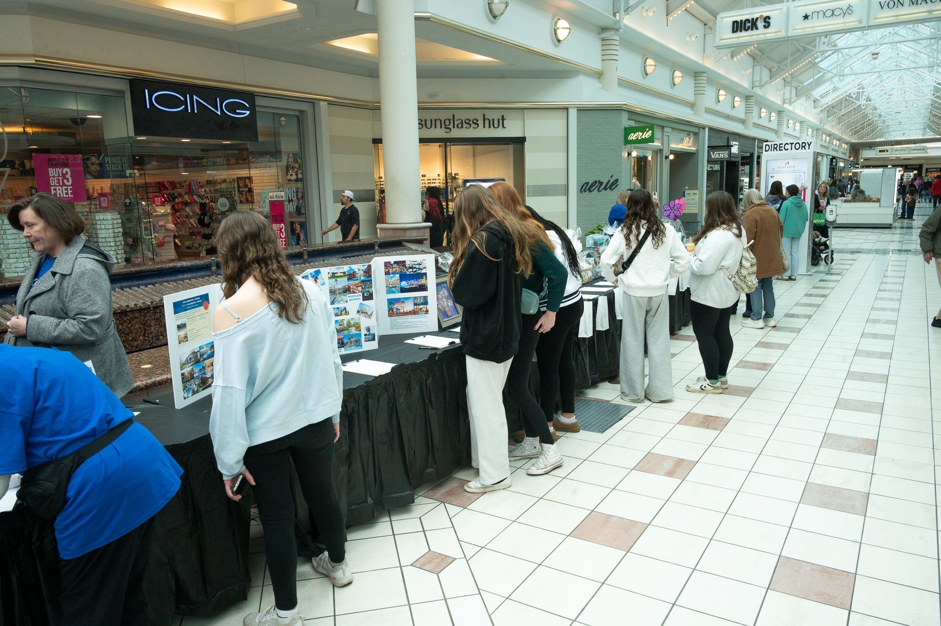 Five people looking at display tables