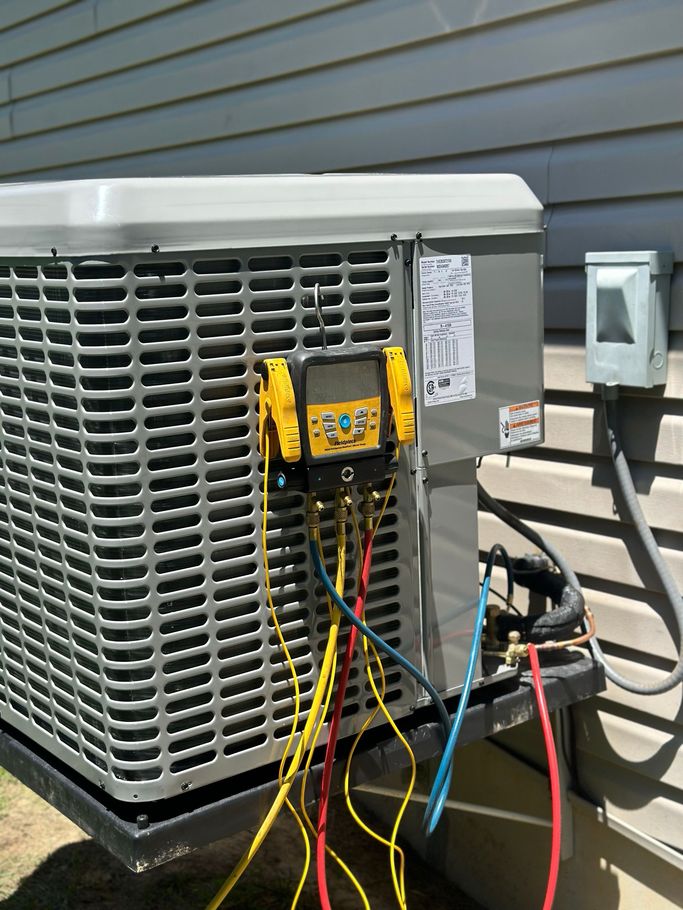 A Man in a Blue Hat is Working on an Air Conditioner — Holts Summit, MO — JC HVAC & Sons LLC A Man in a Blue Hat is Working on an Air Conditioner — Holts Summit, MO — JC HVAC & Sons LLC