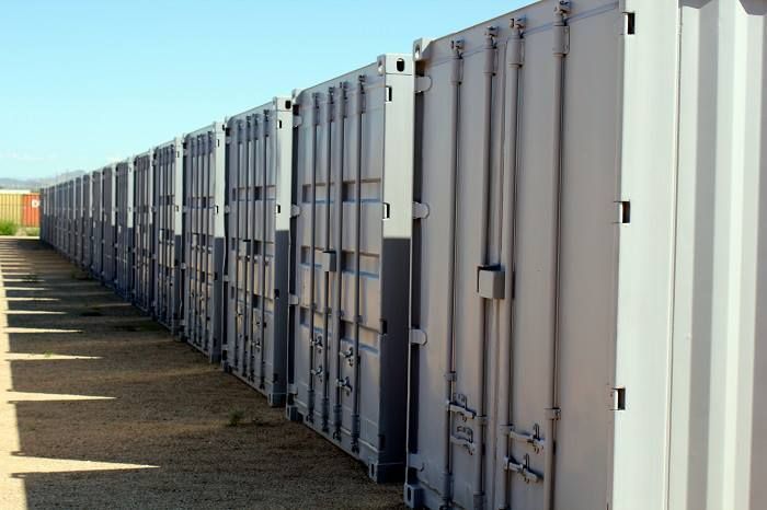 A row of shipping containers are lined up in a row