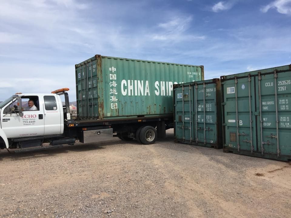 A truck is towing a green shipping container that says china ship on it.