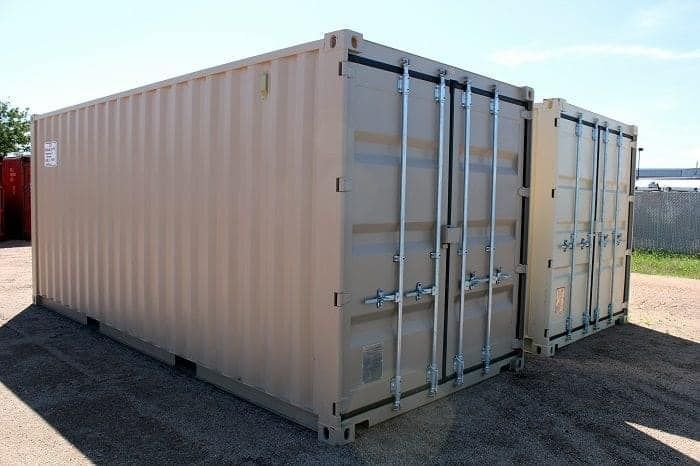 Two shipping containers are sitting next to each other in a parking lot.