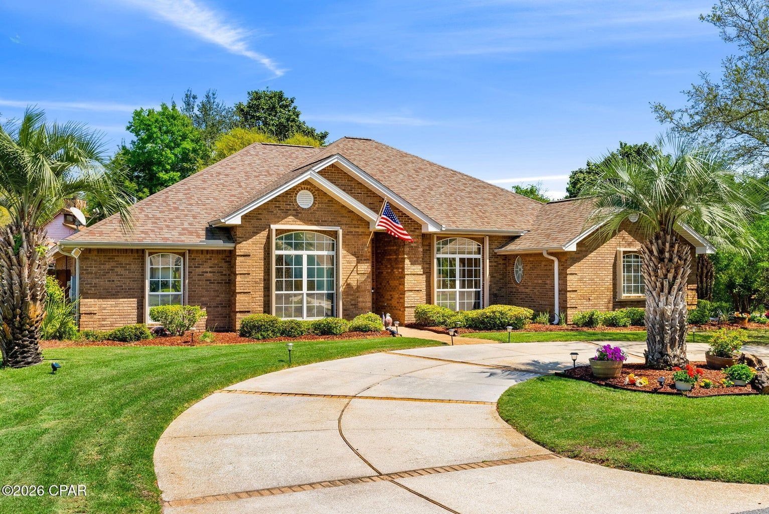 A well landscaped traditional all brick single story home with a circular drive in Panama City.