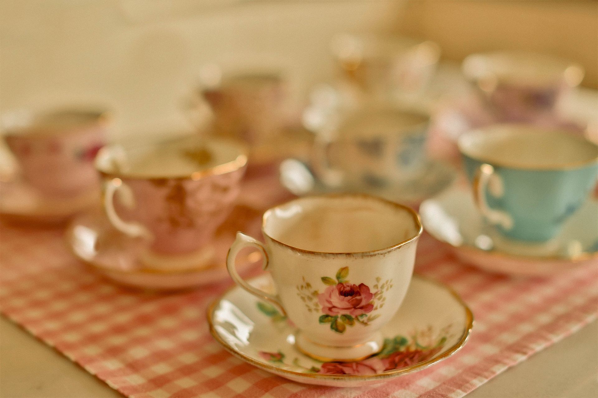 A group of tea cups and saucers are sitting on a table.