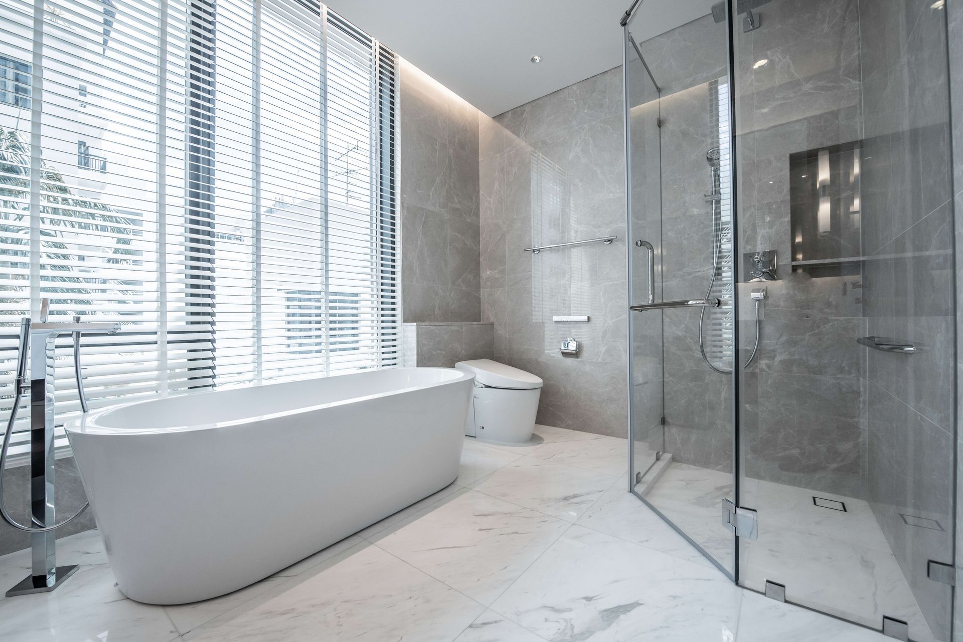 A bathroom with a bathtub , toilet , and shower stall.