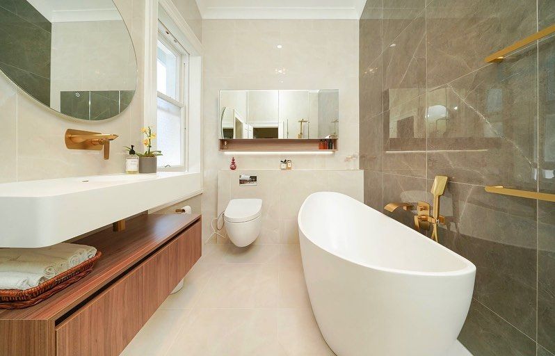 A bathroom with two sinks , a toilet , and a large mirror.