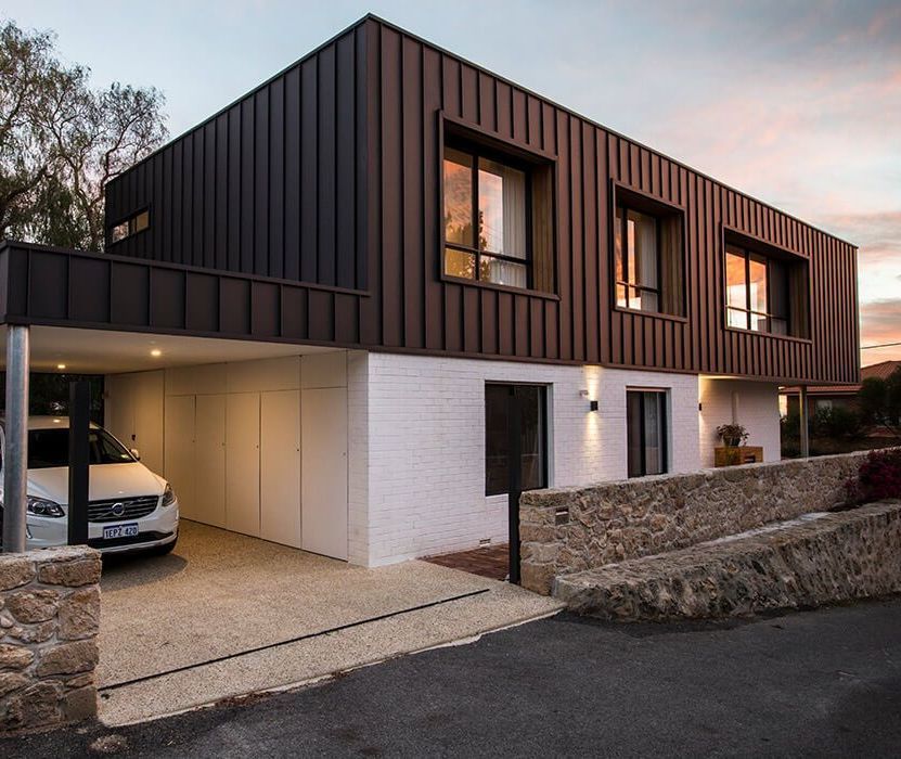 A car is parked in front of a house that has been remodeled.