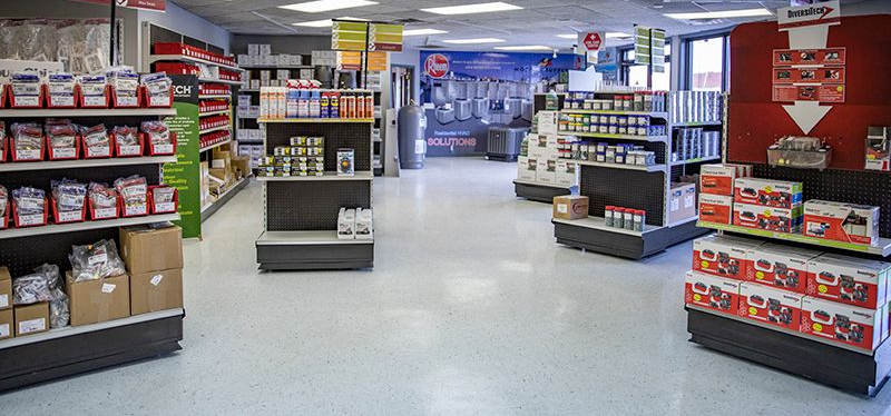 Hardware store interior with shelves of products and signage, displaying various items for sale.
