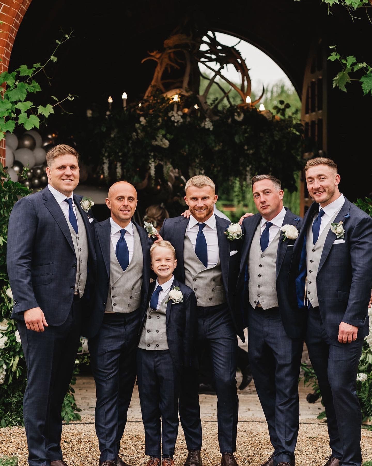 A group of men in suits and ties are posing for a picture.