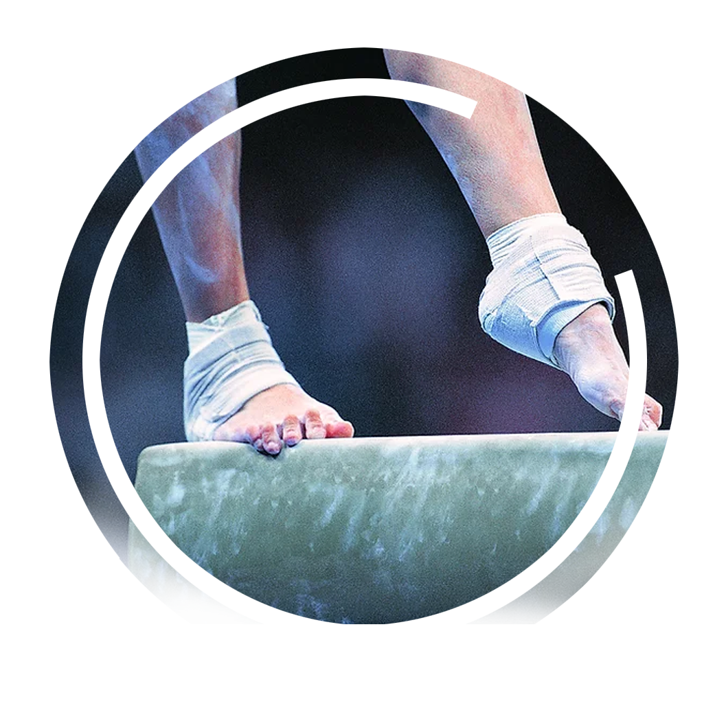 A gymnast is standing on a balance beam with their feet wrapped in bandages