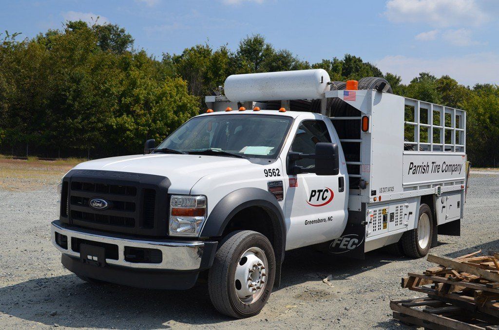 White Ford utility truck with PRG logo parked outdoors.