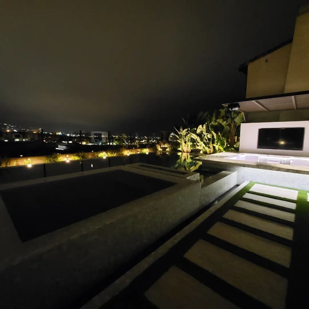 A large swimming pool is lit up at night