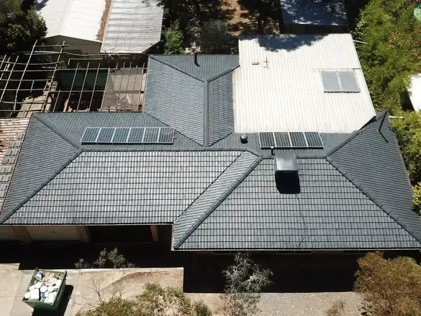 An aerial view of a house with solar panels on the roof