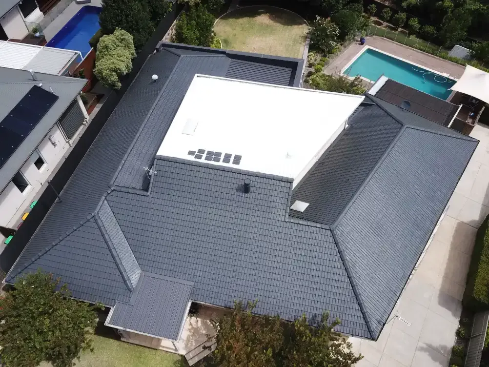 An aerial view of a house with a swimming pool in the backyard