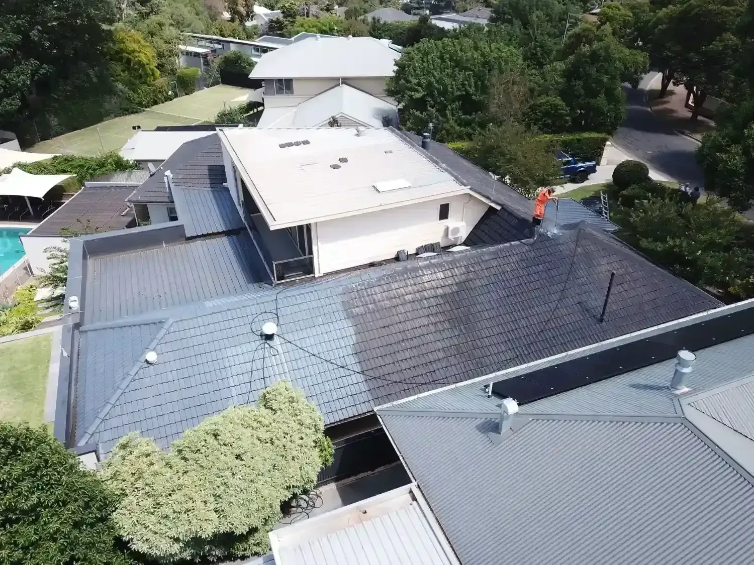 An aerial view of a house with a roof that is being painted.