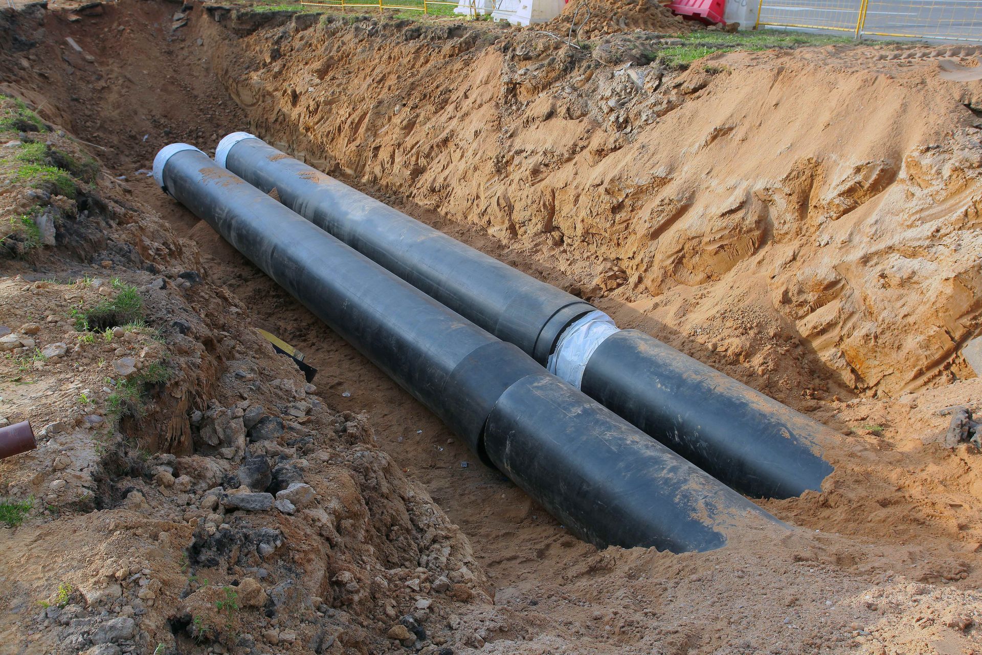 Large pipes set in an excavated trench during sewer line replacement work Large pipes set in an excavated trench during sewer line replacement work