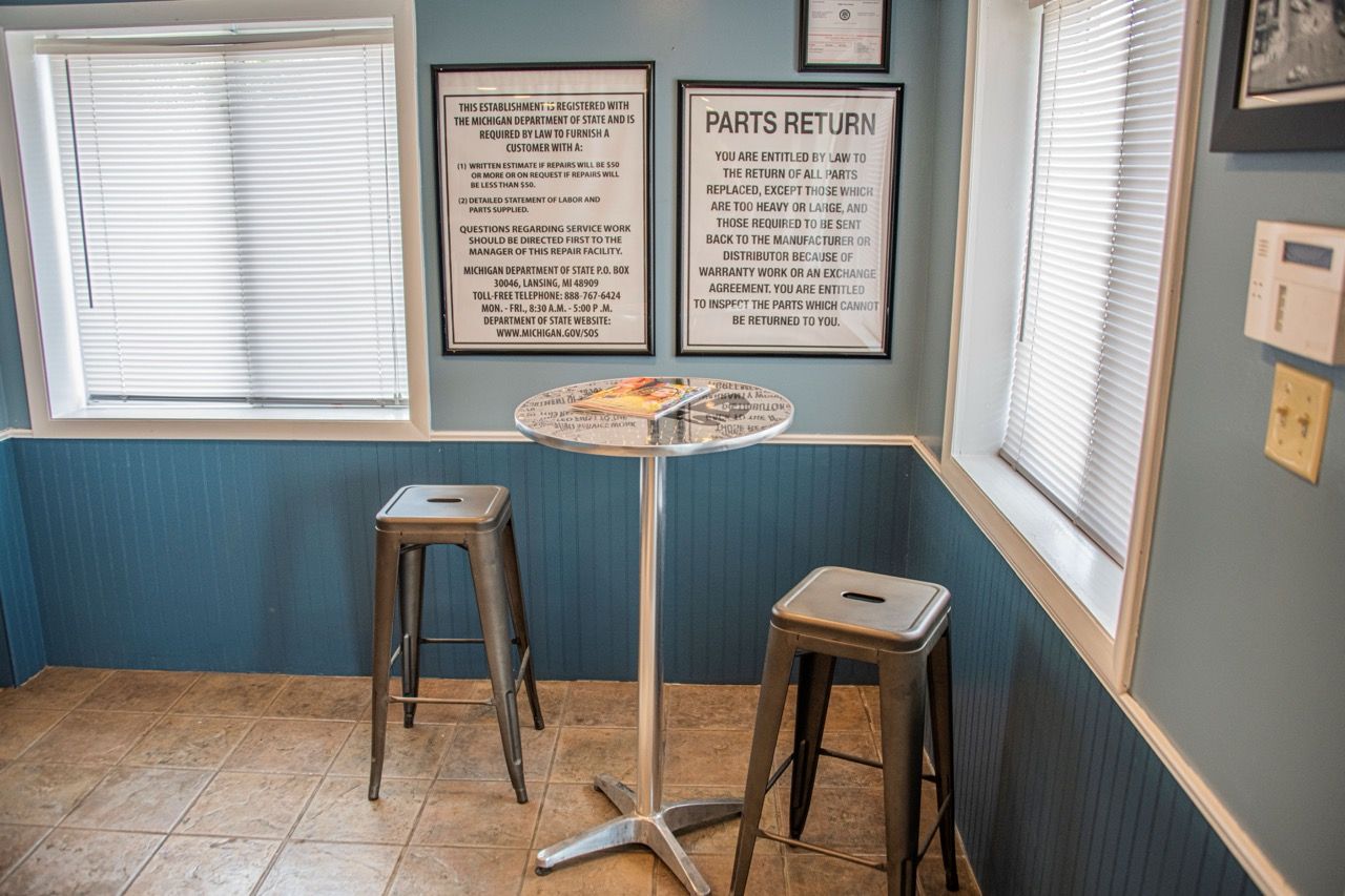 A small corner with a table, two stools, two windows with blinds, and blue wainscoting | Jackson, MI