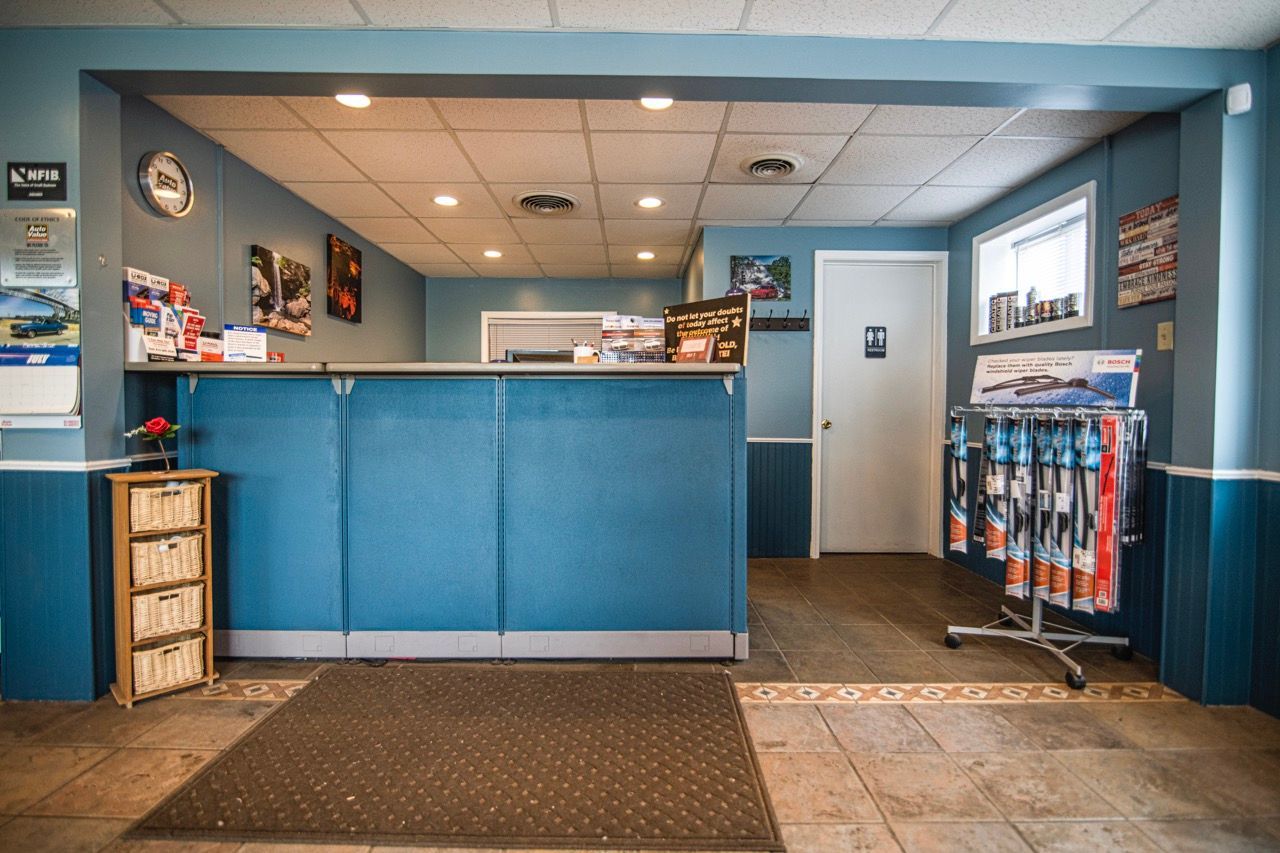 Reception area of an auto repair shop with a blue counter, file cabinet, and wiper blades for sale | Jackson, MI