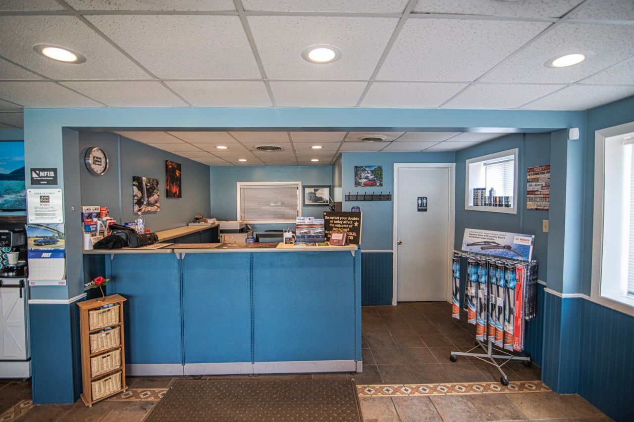 Interior of a reception area with blue walls and counter, desk, waiting area, and products for sale | Jackson, MI