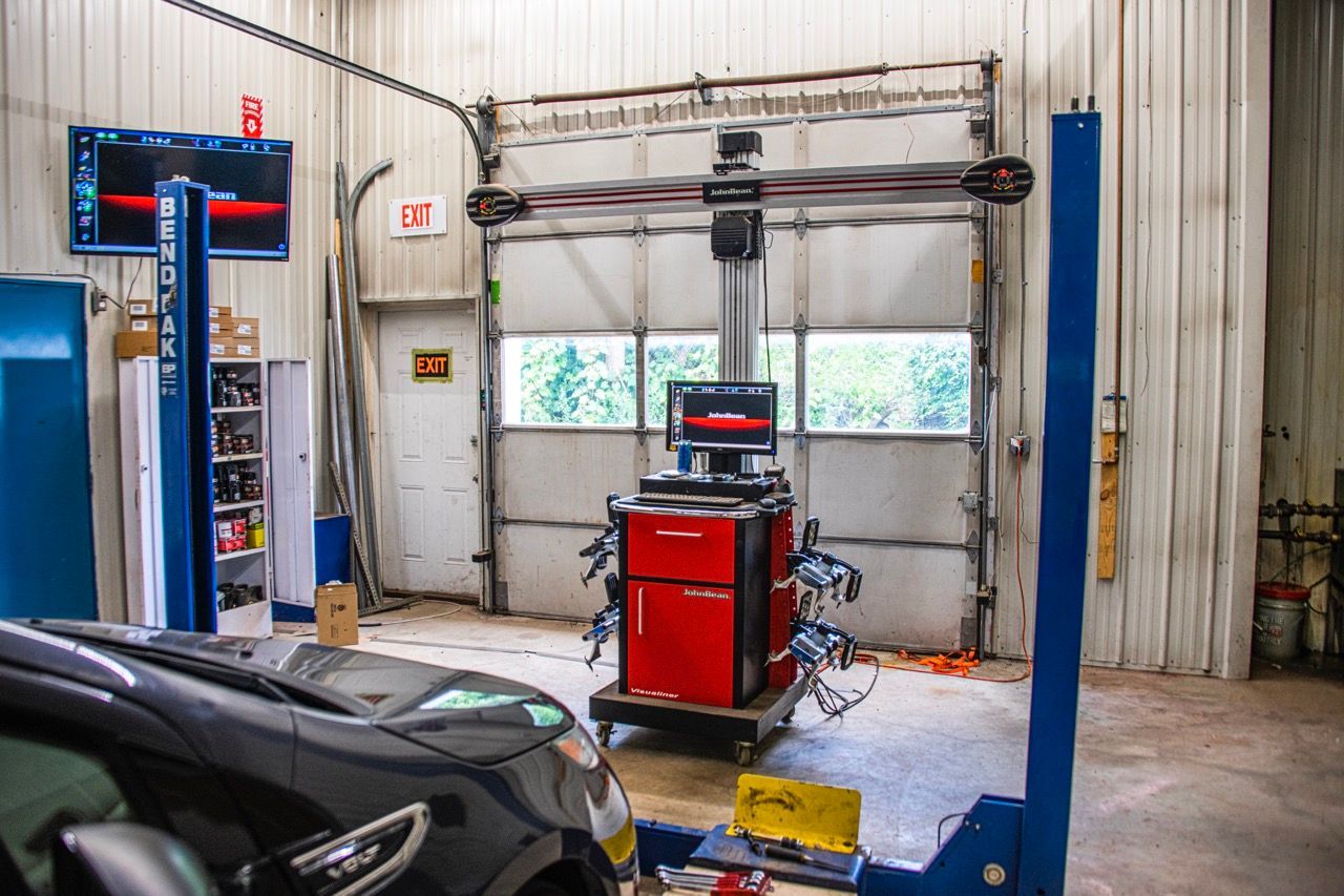 Car alignment machine in a garage bay with a car on a lift | Jackson, MI