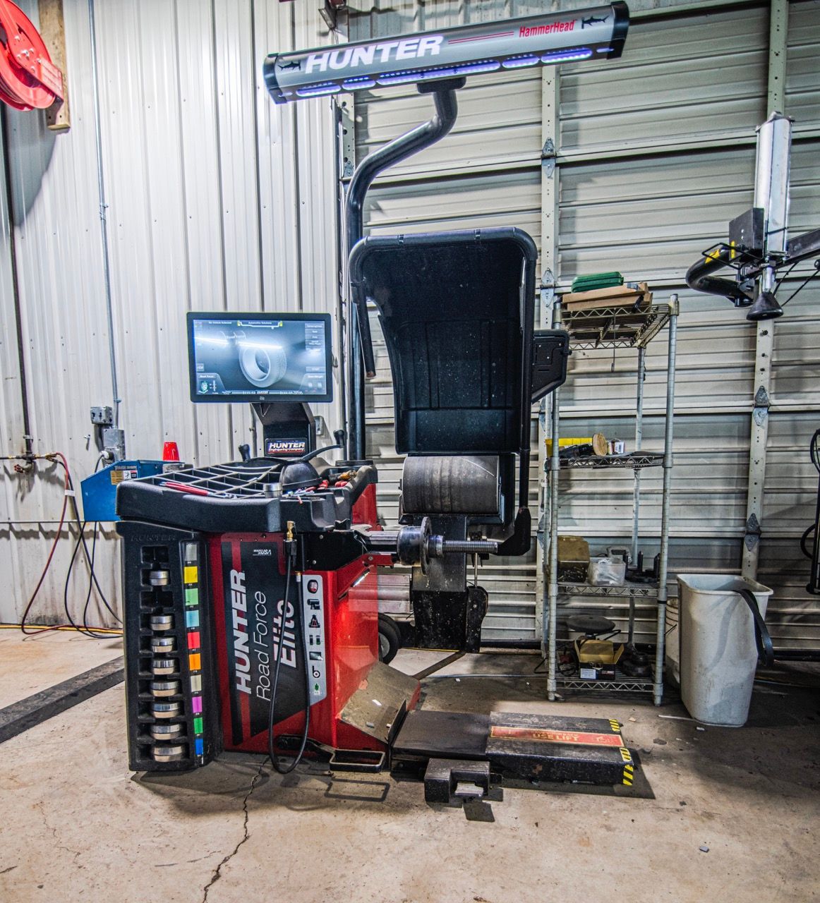 Hunter wheel alignment machine in a garage. Red and black equipment, computer screen, and overhead light | Jackson, MI