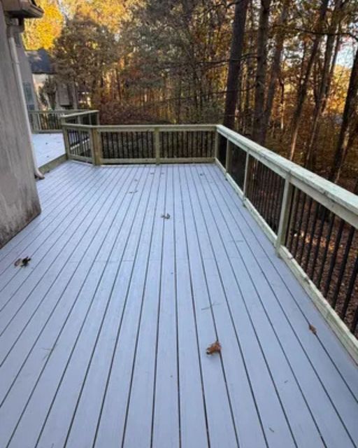 Deck construction with painted grey composite-style decking boards