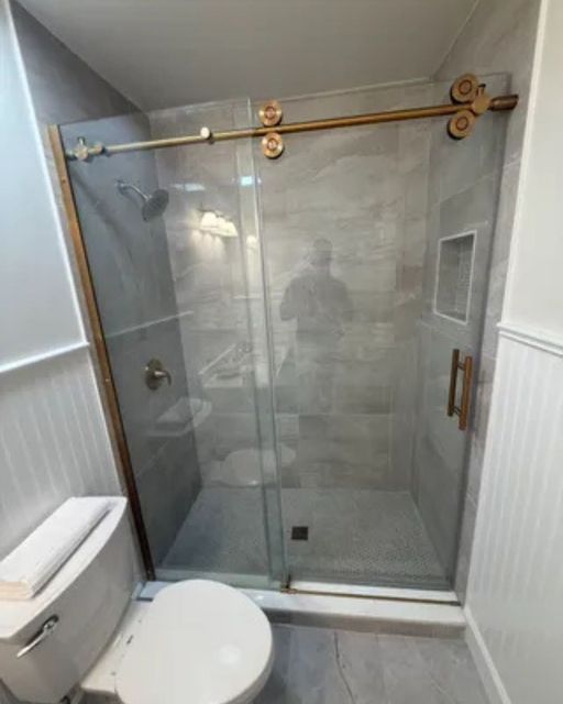 Bathroom renovation with frameless sliding glass shower enclosure