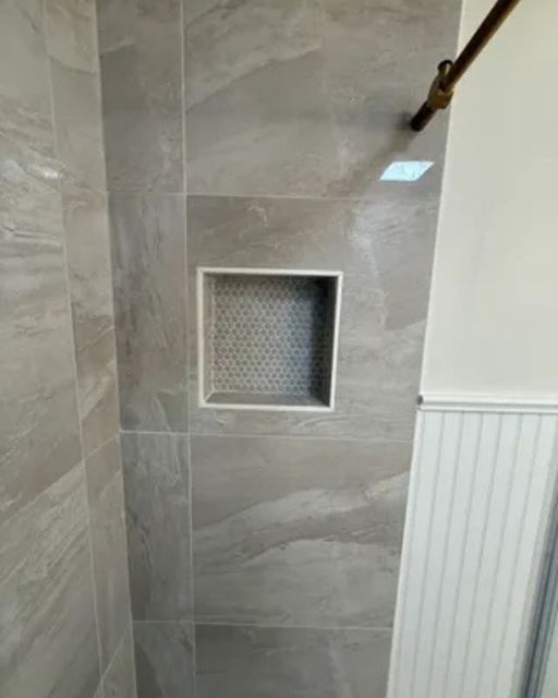 Shower detail with large-format grey marble-look tile walls