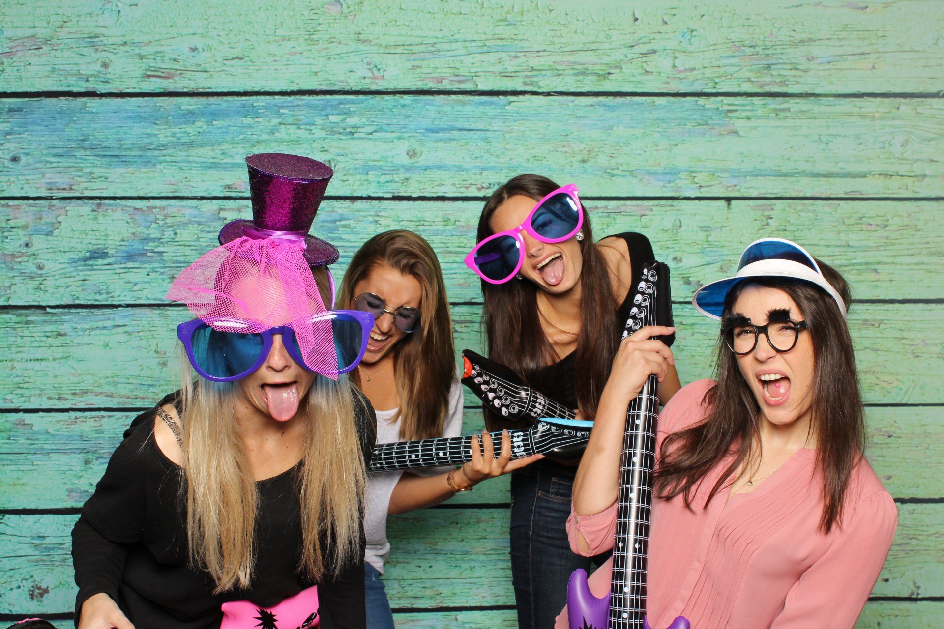 A group of young women are posing for a picture in a photo booth.