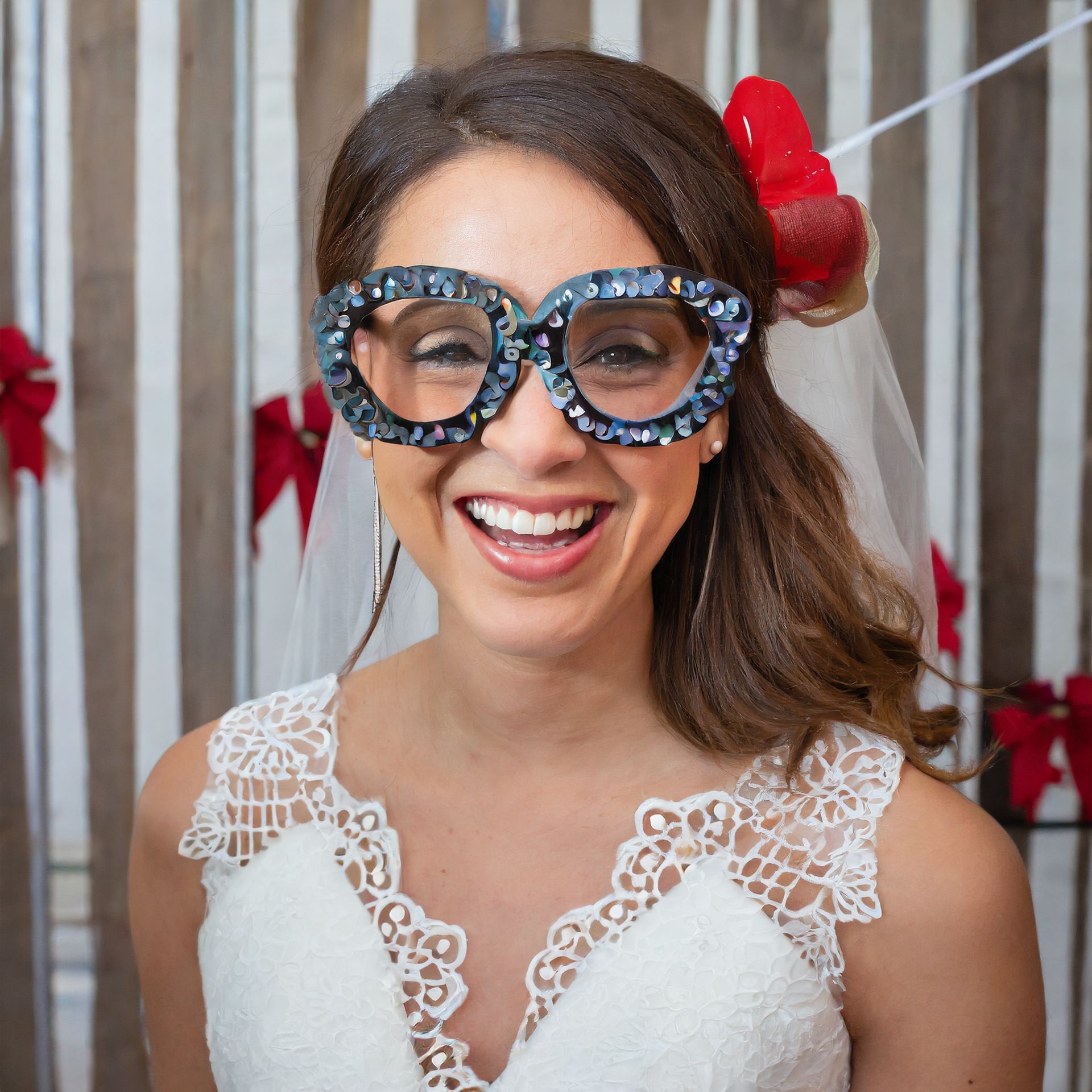 A bride wearing glasses and a veil is smiling